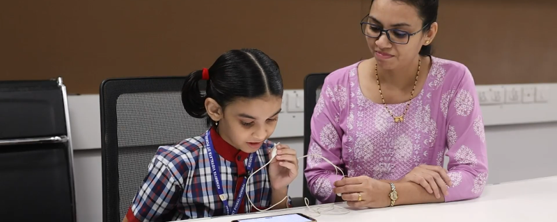  वाचन कौशल्य चाचणी घेताना शालेय विद्यार्थिनी व सहाय्यक शिक्षिका (श्रेय : संशोधक) 